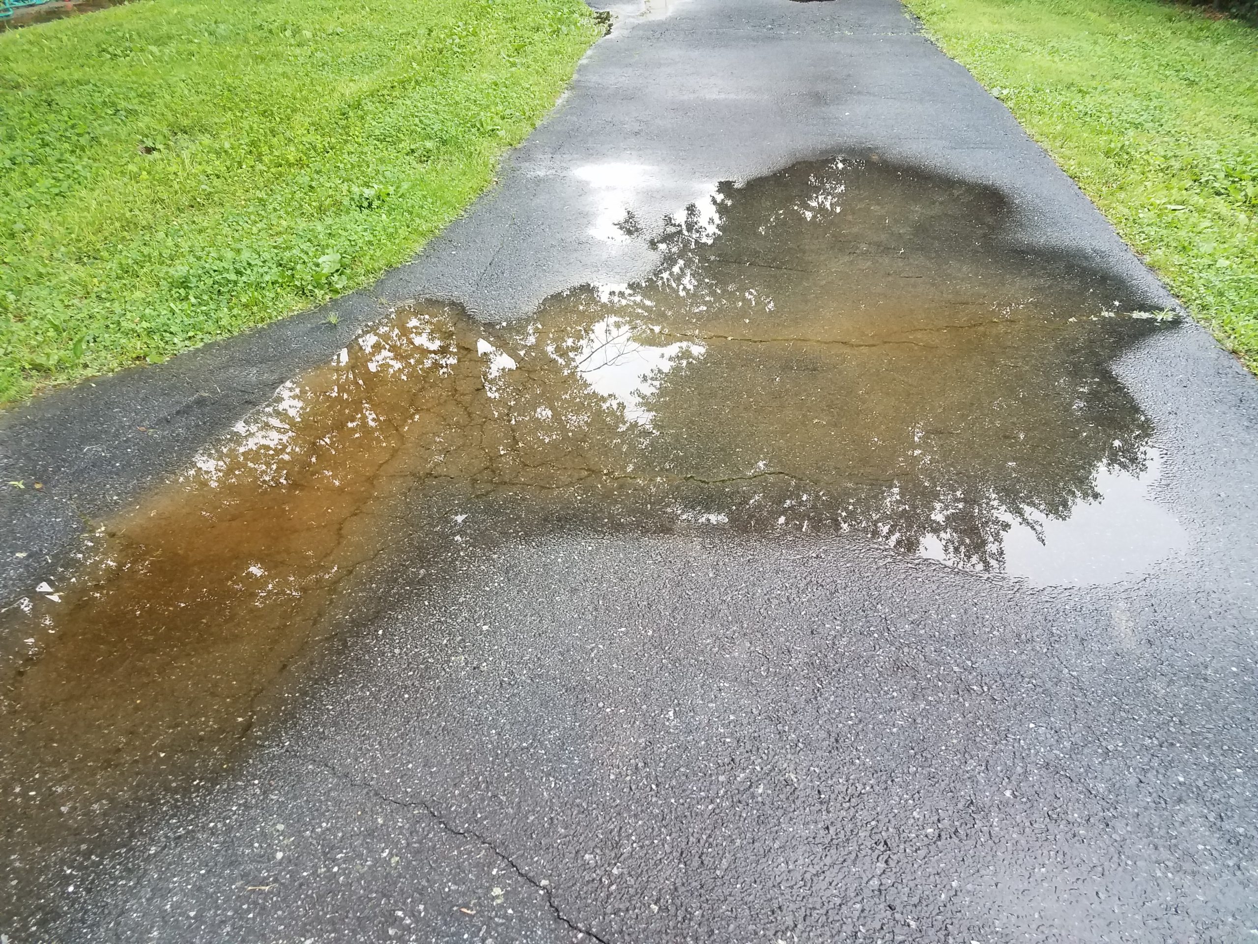 Big,Puddle,In,Asphalt,Driveway